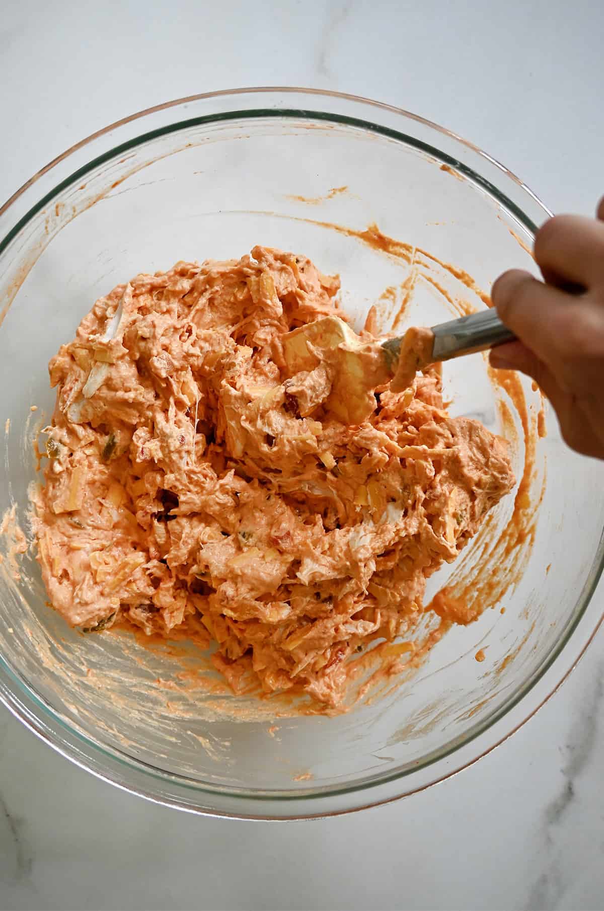 Buffalo chicken dip mixture in a glass bowl.