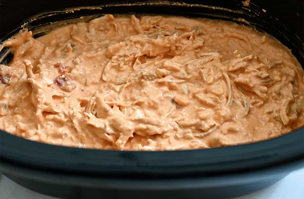 A slow cooker containing buffalo chicken dip.