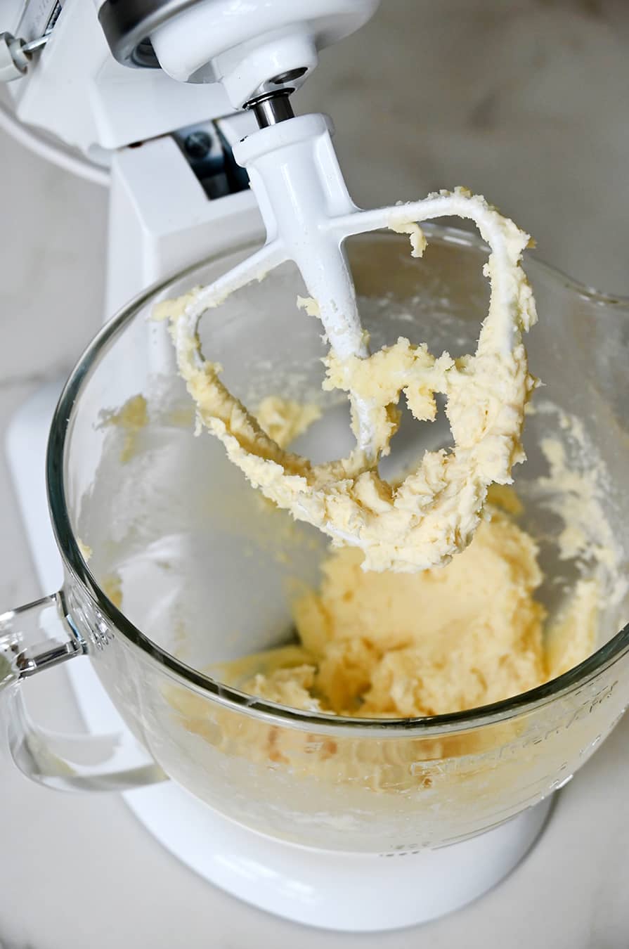 Brie cheese in a stand mixer glass bowl with paddle attachment