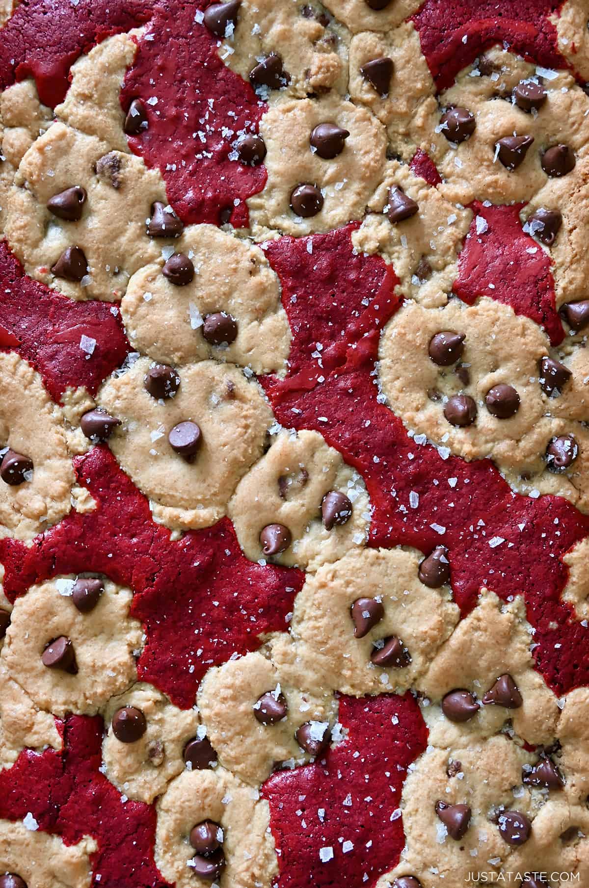 A close-up view of red velvet brownie chocolate chip cookies (brookies) sprinkled with large-flake sea salt.