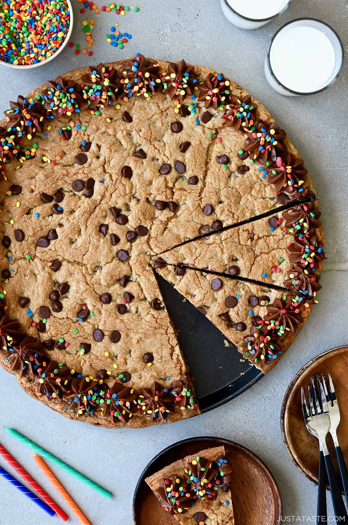 A top-down view of a Chocolate Chip Cookie Cake with chocolate frosting and rainbow sprinkles.