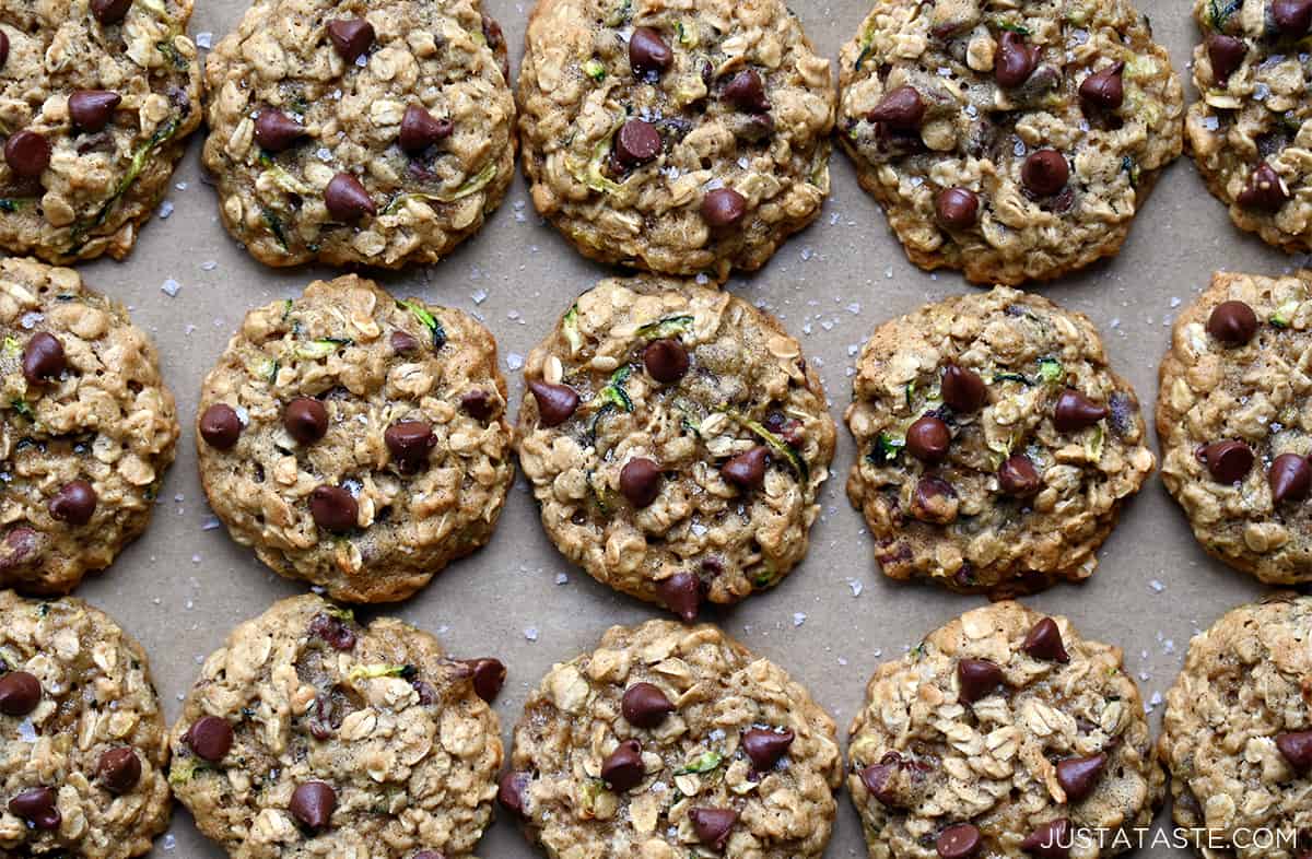 Three perfect rows of zucchini oatmeal chocolate chip cookies garnished with large-flake sea salt.