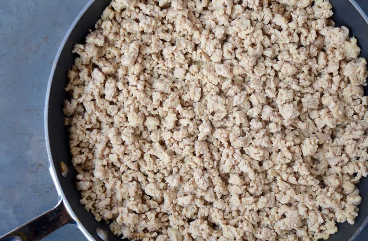 A large skillet full of cooked ground chicken.