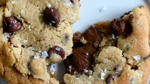 A chocolate chip cookie broken in half with a gooey Nutella filling.