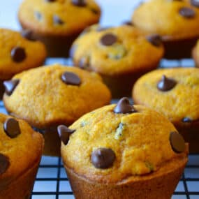 Pumpkin chocolate chip muffins on a wire cooling rack.