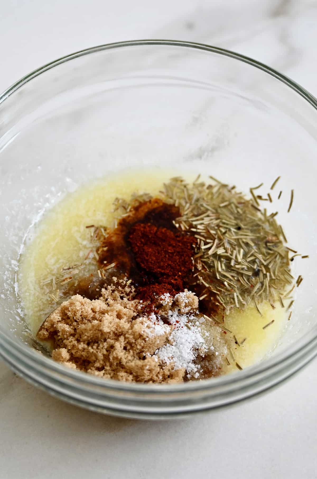 Melted butter, spices, salt and brown sugar in a small glass mixing bowl.