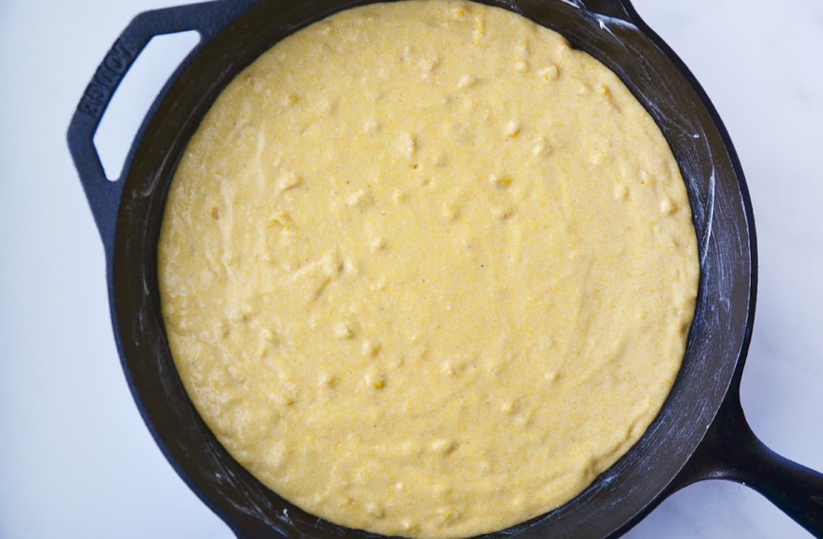 Cornbread batter in a cast iron skillet.