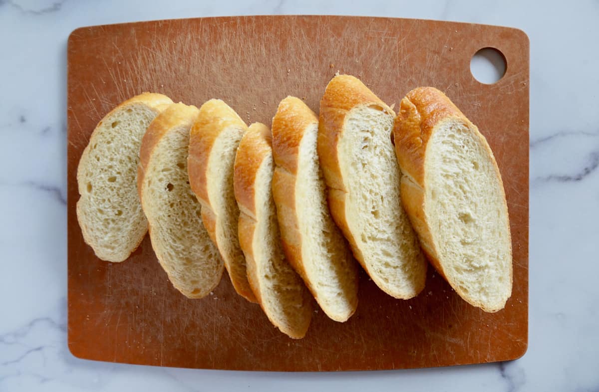 Seven thick slices of bread on a cutting board.