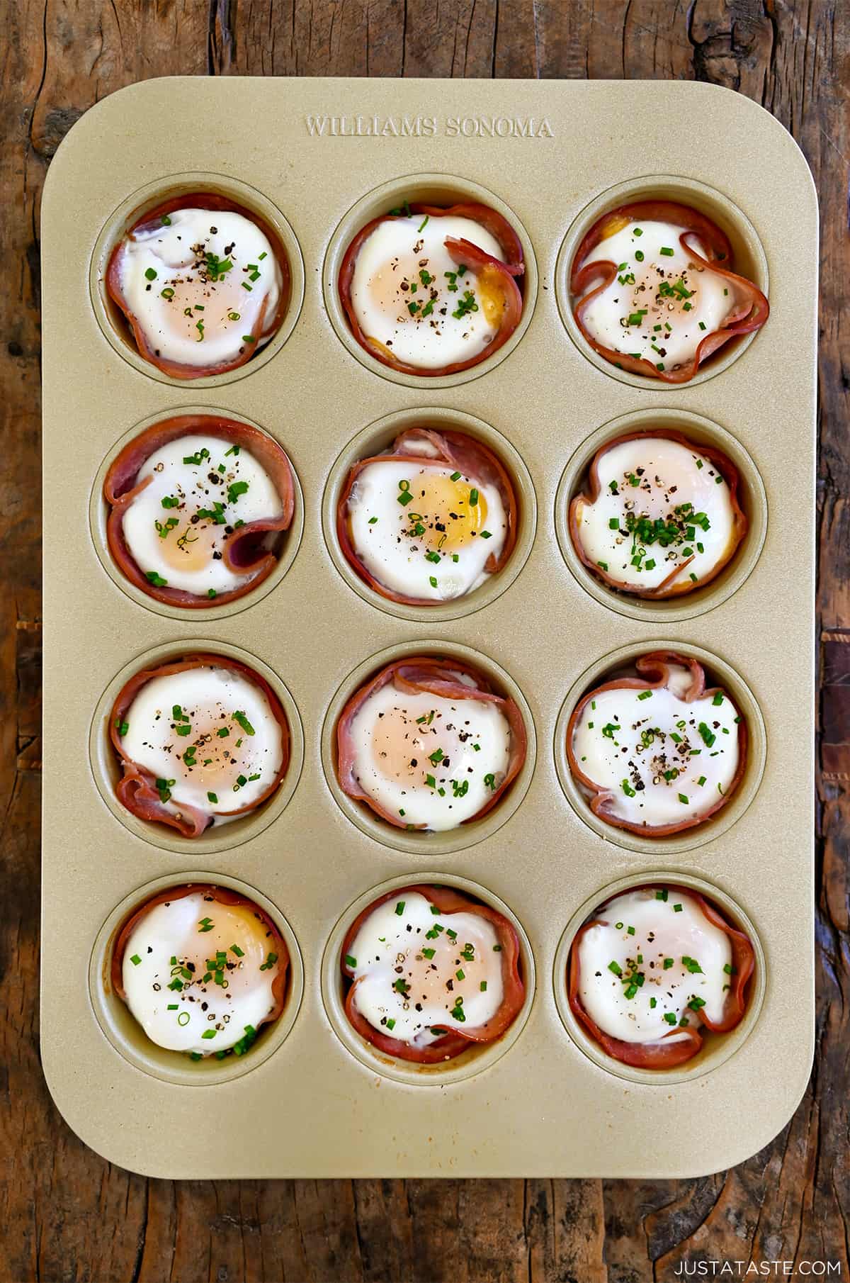 Oven baked ham and egg cups in a standard 12-cup muffin pan.