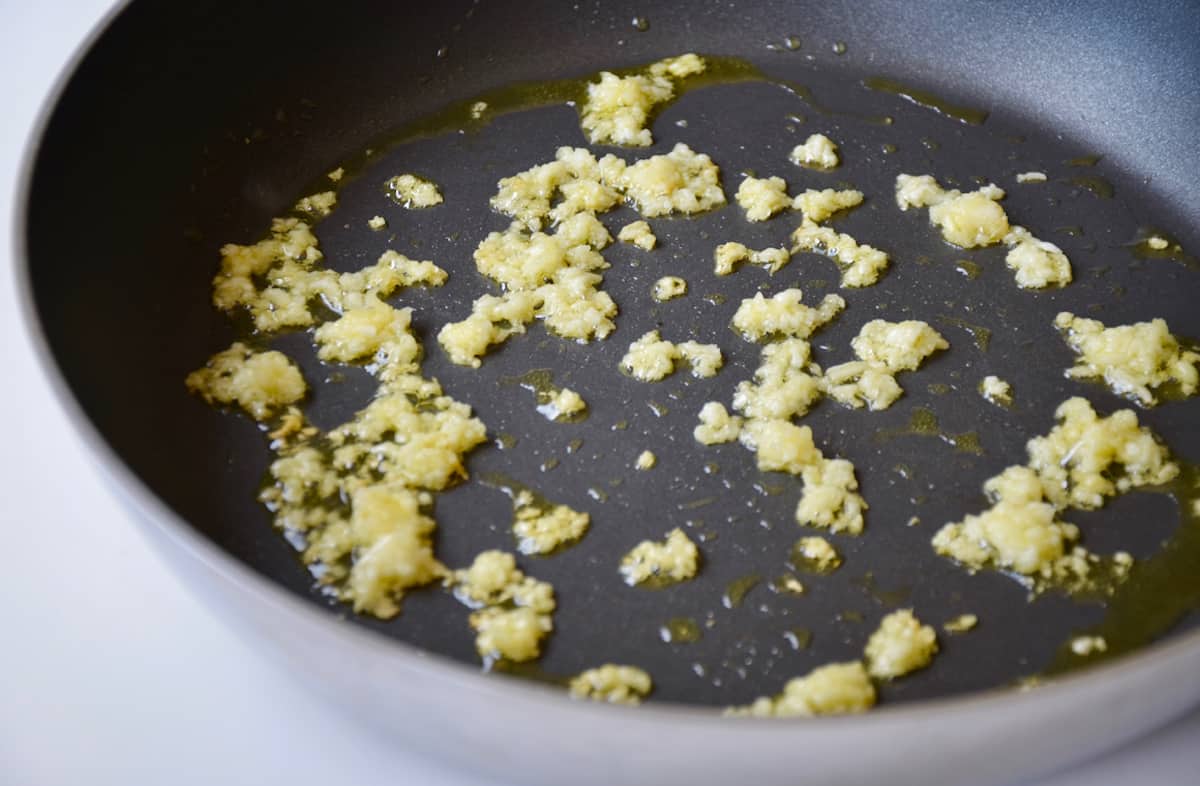 Minced garlic being sautéed in a nonstick skillet.