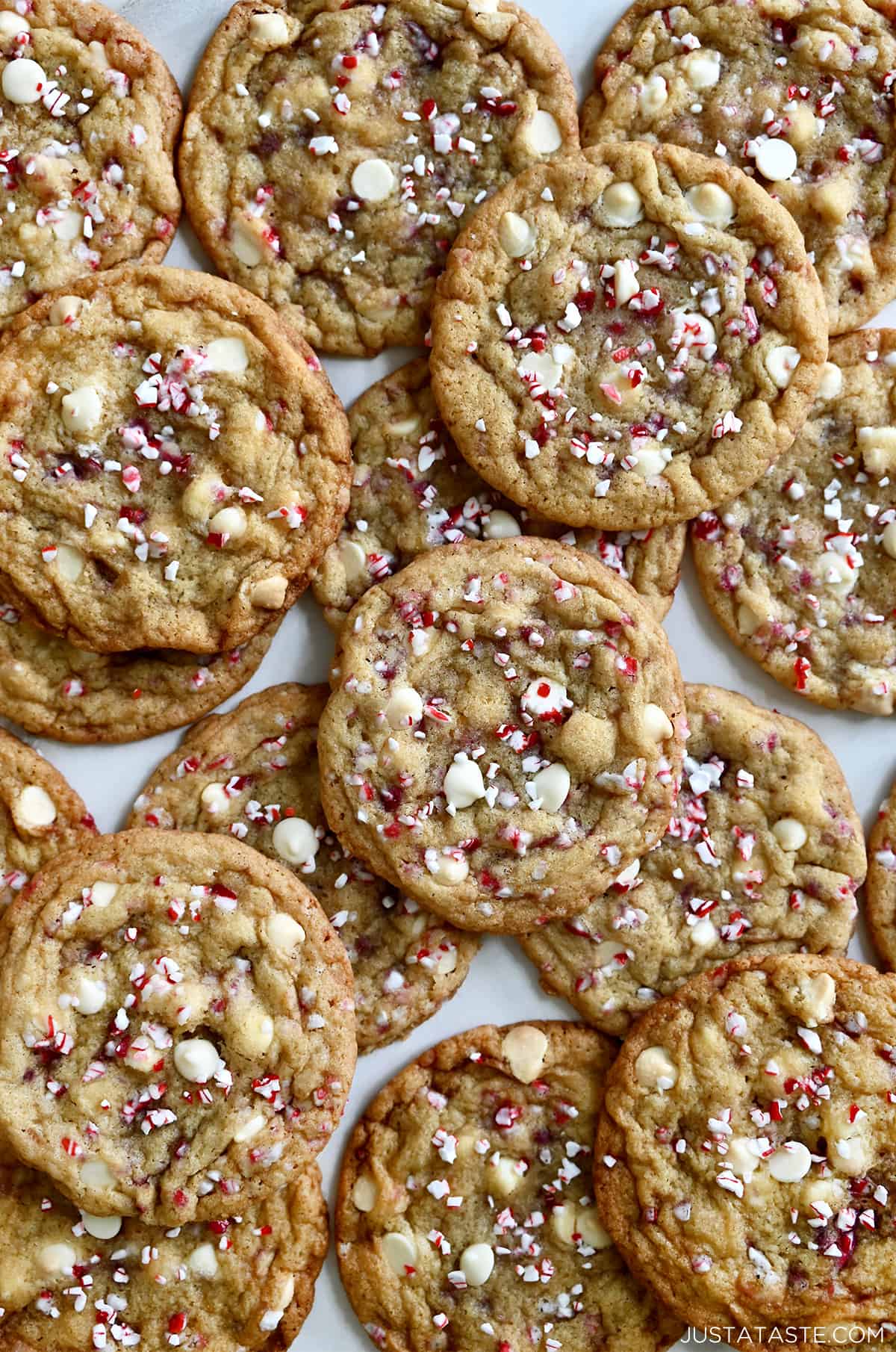 White chocolate chip cookies studded with crushed candy canes piled atop each other.