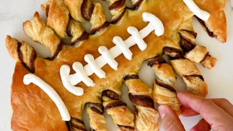 Puff pastry twisted and baked in the shape of a football with vanilla frosting laces.