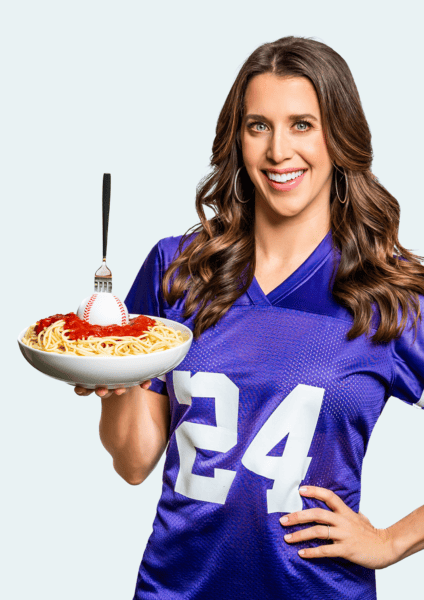 Kelly Senyei in a purple football jersey holding a bowl of past with a baseball in it