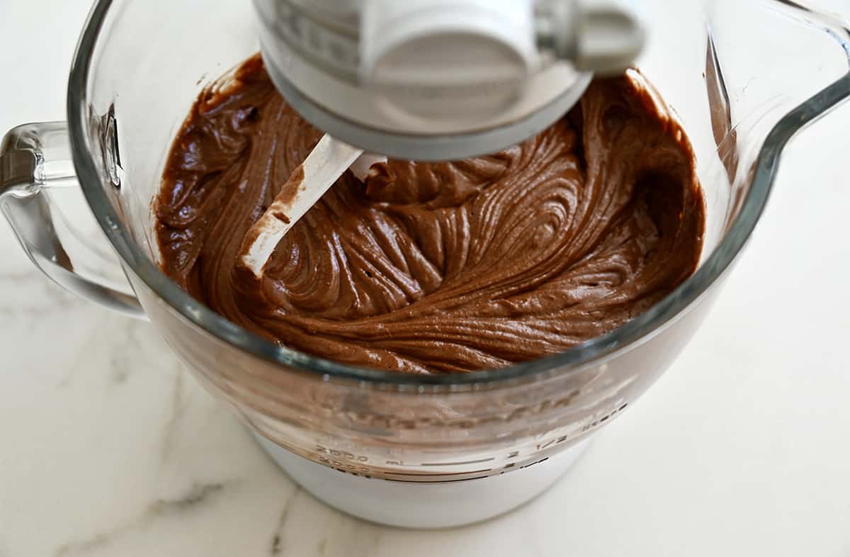 Chocolate cupcake batter in the bowl of a stand mixer fitted with the paddle attachment.