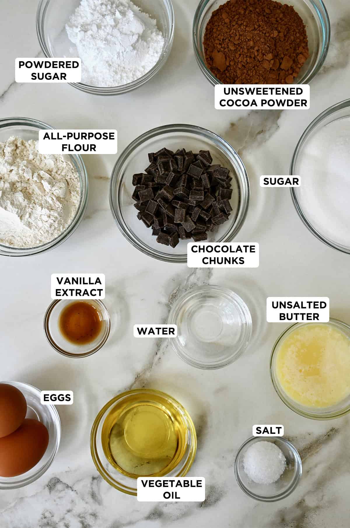 Ingredients for cocoa powder brownies in various sizes of glass bowls.