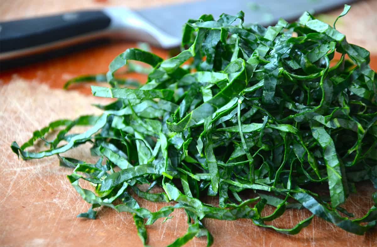 A handful of shredded kale on a cutting board.