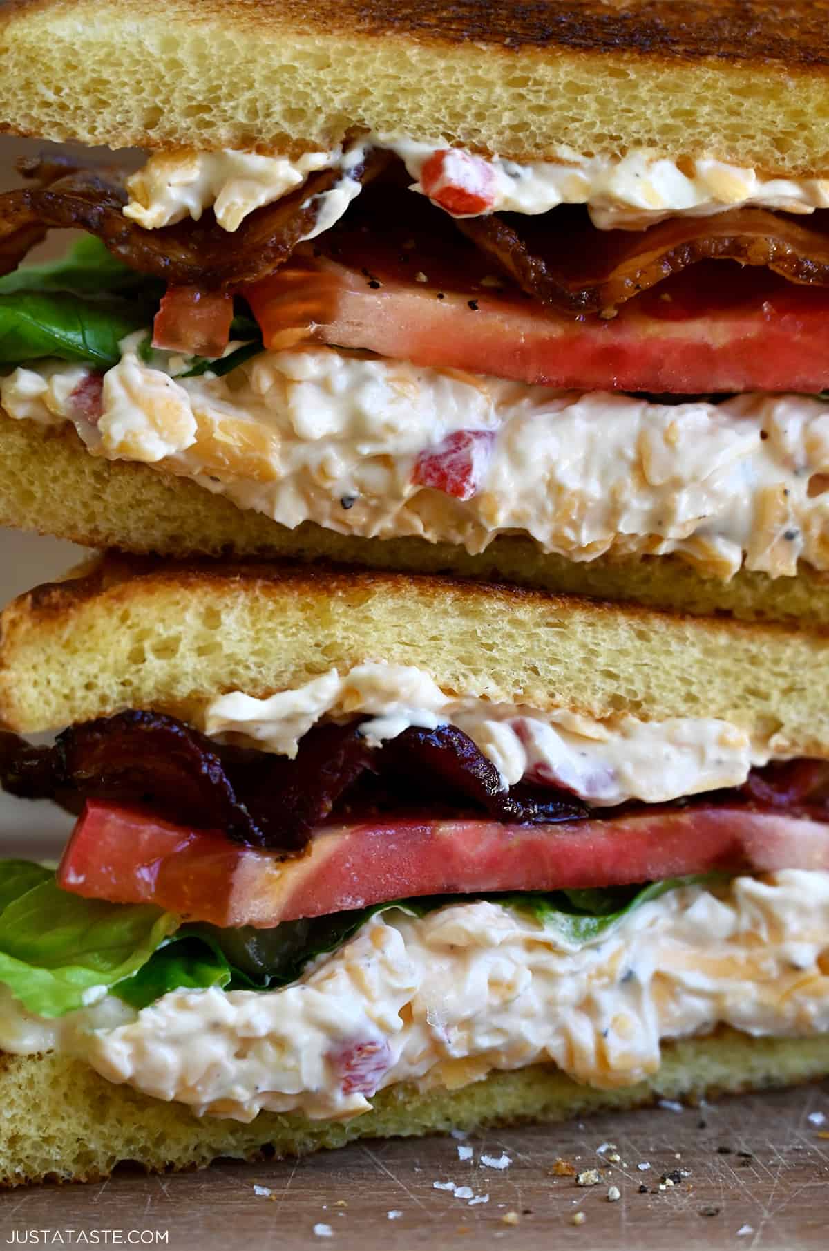 Pimento cheese oozy out of a BLT sandwich. 