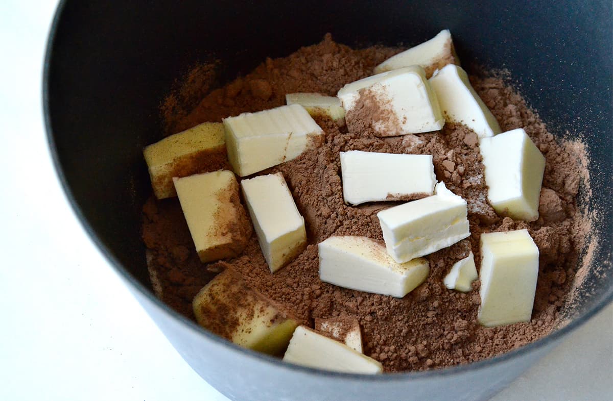Cubed butter and cocoa powder in a saucepan.