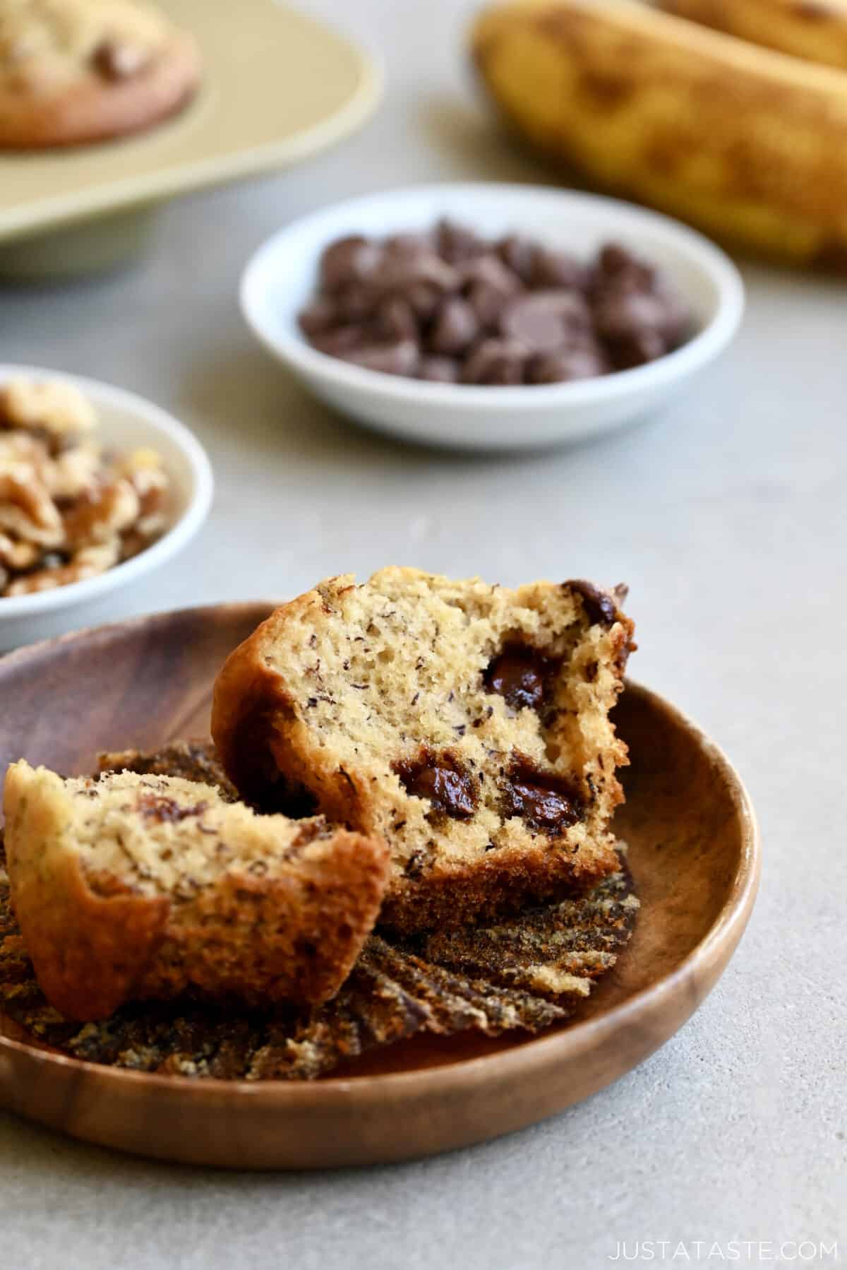 A banana chocolate chip muffin split open on a plate.