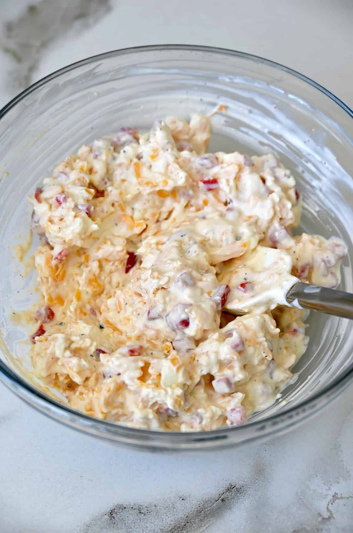 A glass bowl containing pimento cheese.