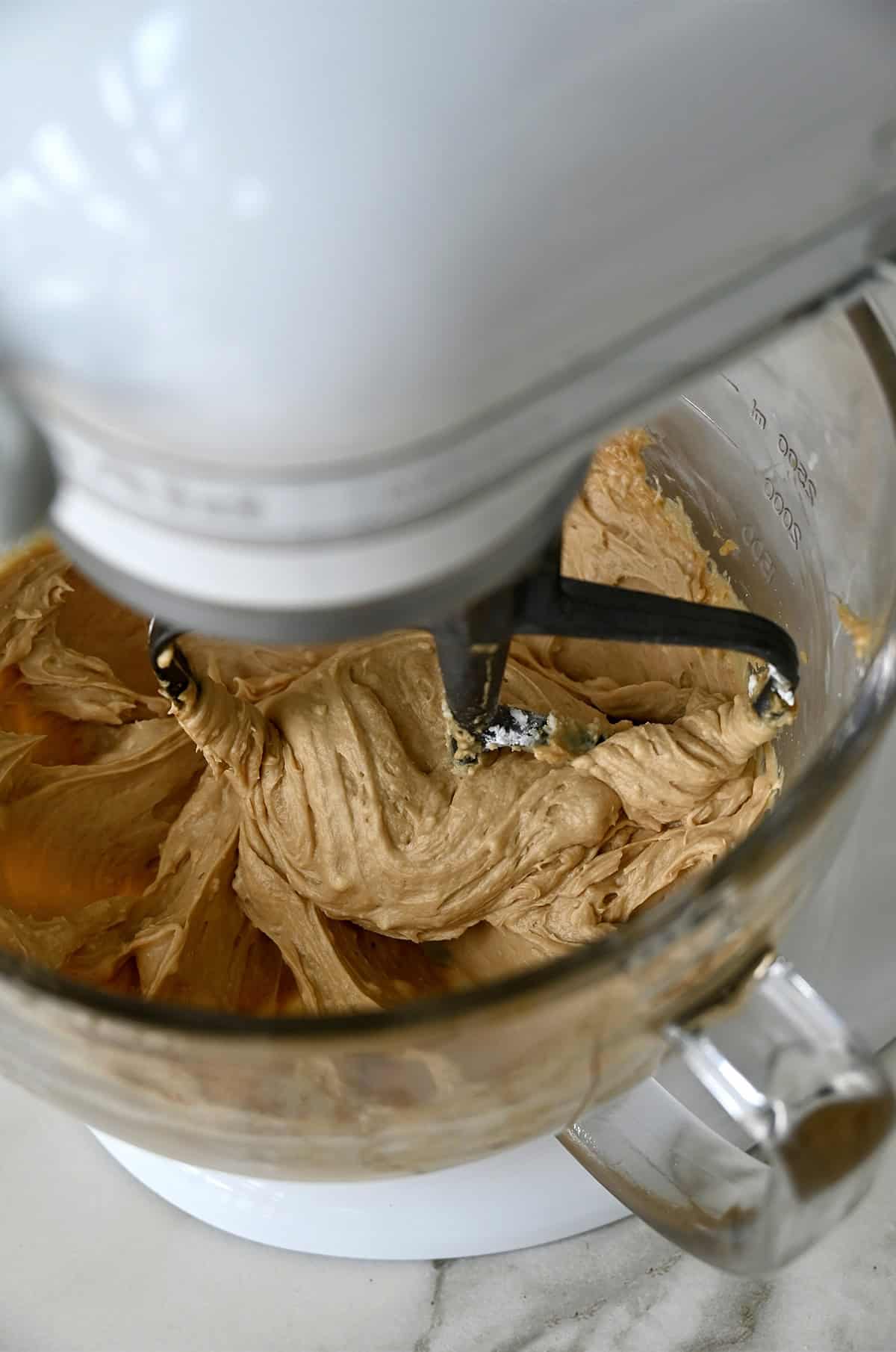 A stand mixer bowl containing easy coffee buttercream frosting.