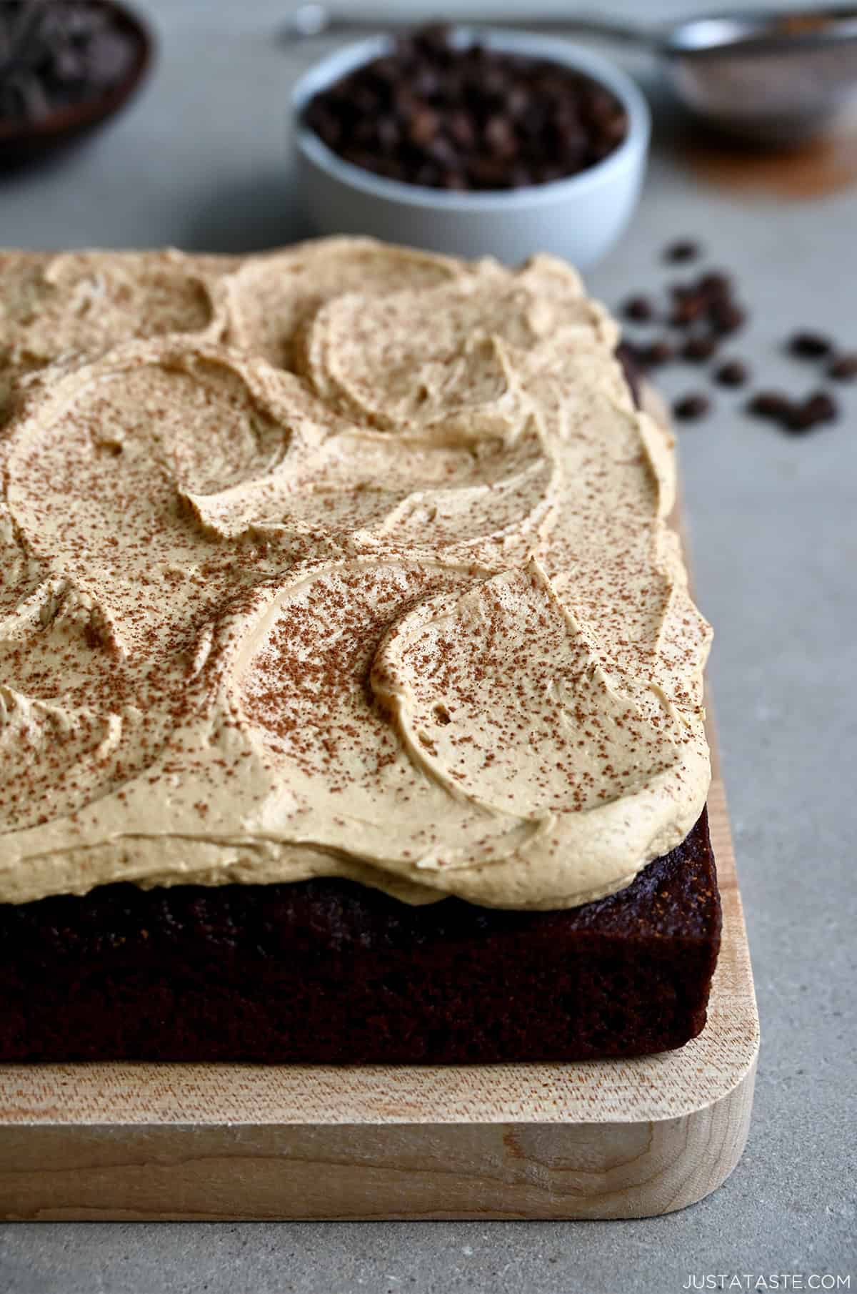 A thick layer of coffee buttercream frosting dusted with cocoa powder atop a chocolate sheet cake.