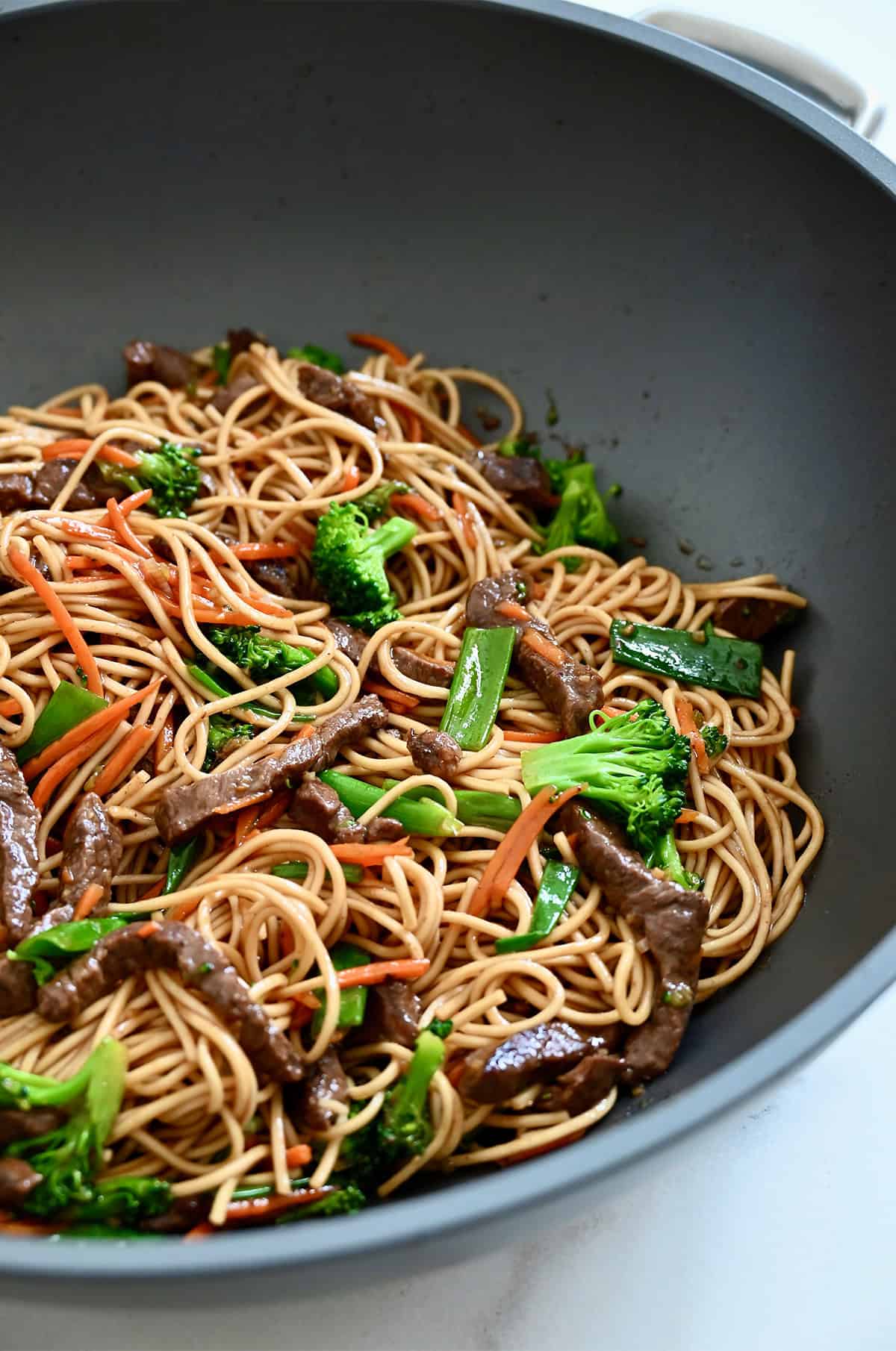 Stir-fried lo mein noodles with beef, broccoli and shredded carrots.