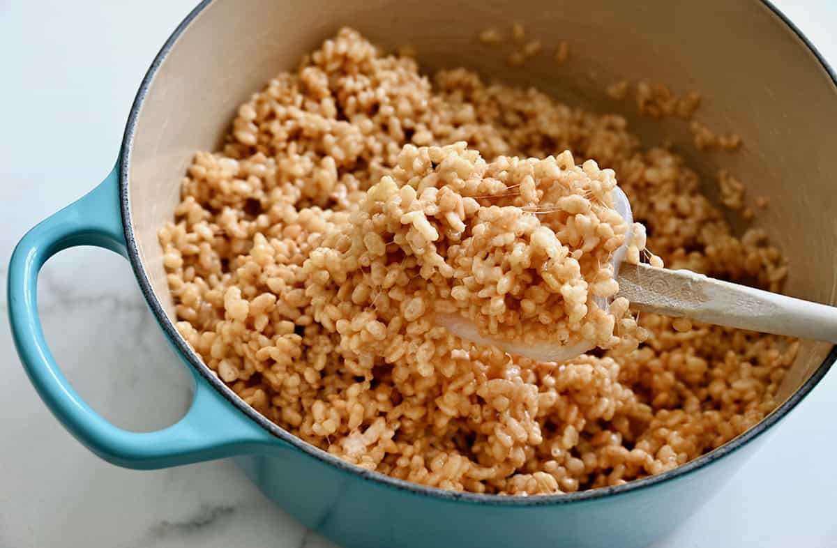 A Rice Krispie-marshmallow mixture in a blue Dutch oven.