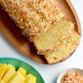 A pineapple coconut loaf with two slices cut off of it.