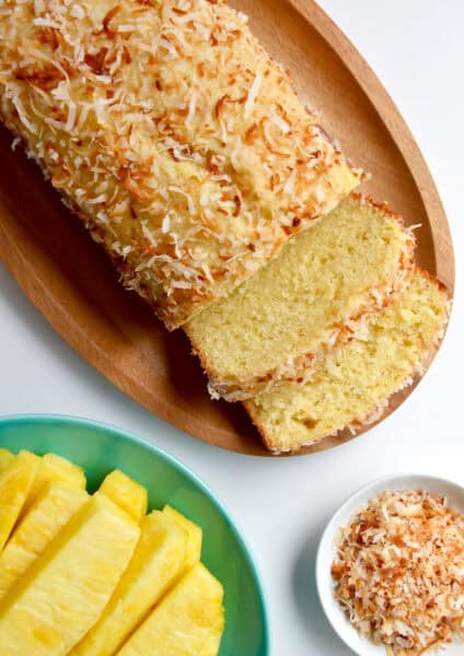 A pineapple coconut loaf with two slices cut off of it.