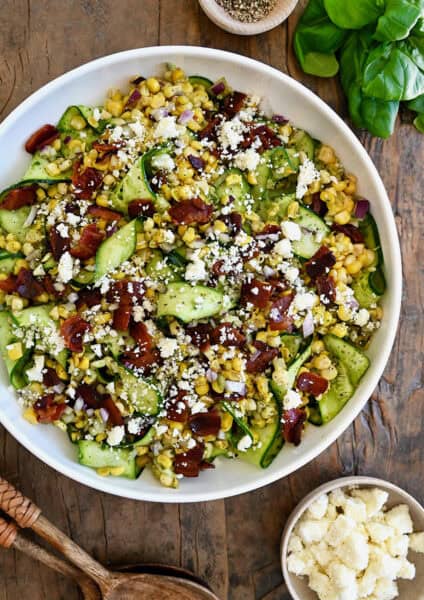 Zucchini and corn salad topped with crispy bacon and cotija cheese.