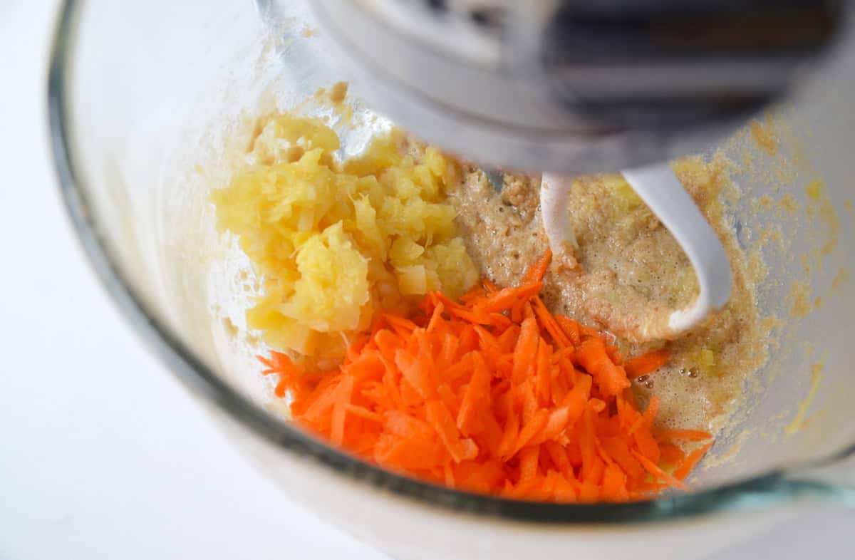 Butter, brown sugar, crushed pineapple and grated carrots in the bowl of a stand mixer.