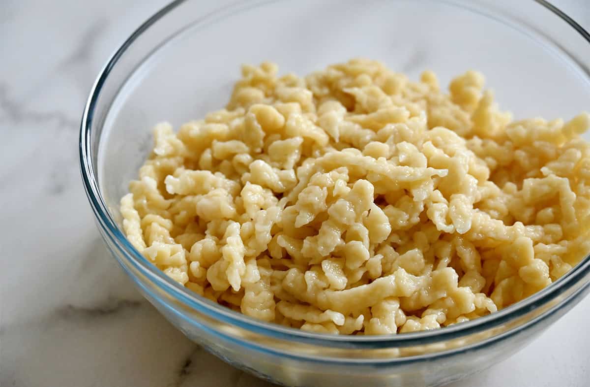 Cooked spaetzle in a glass bowl.