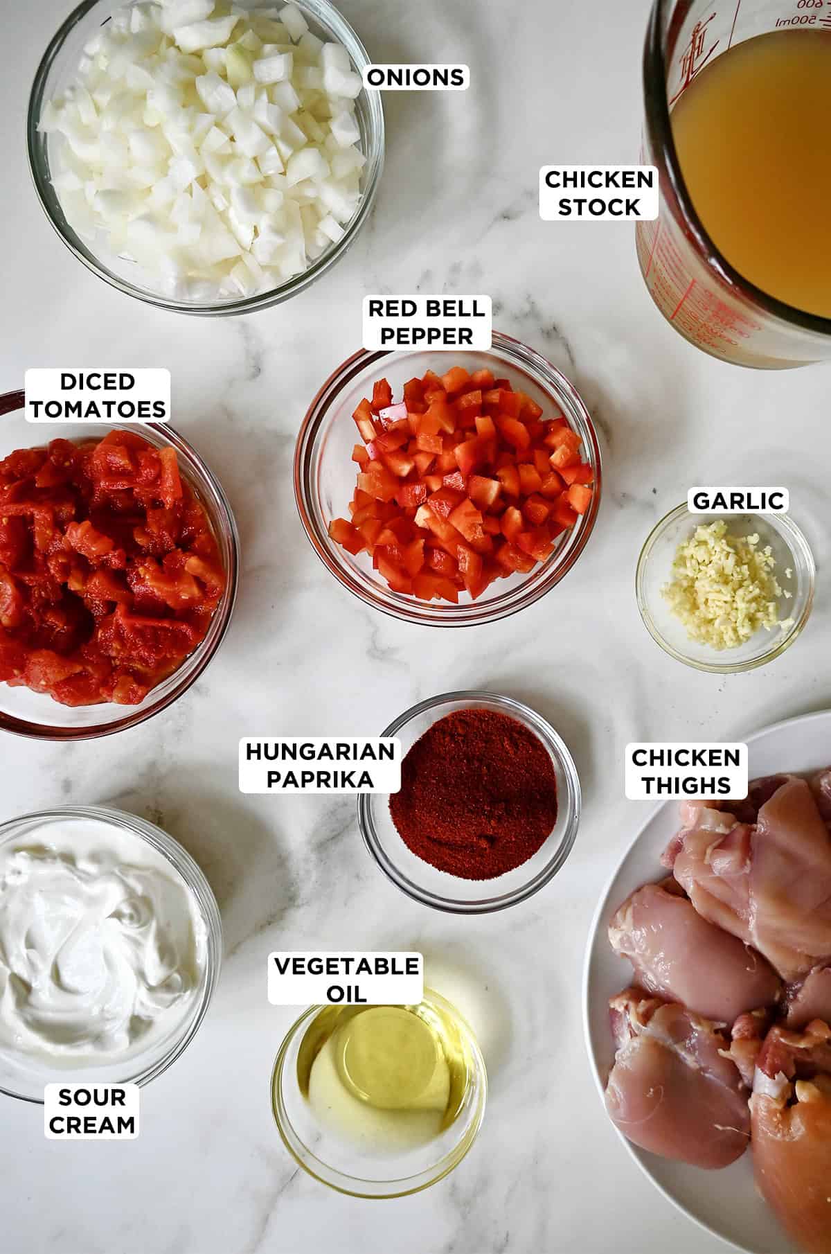 Paprikash ingredients in various sizes of glass bowls.