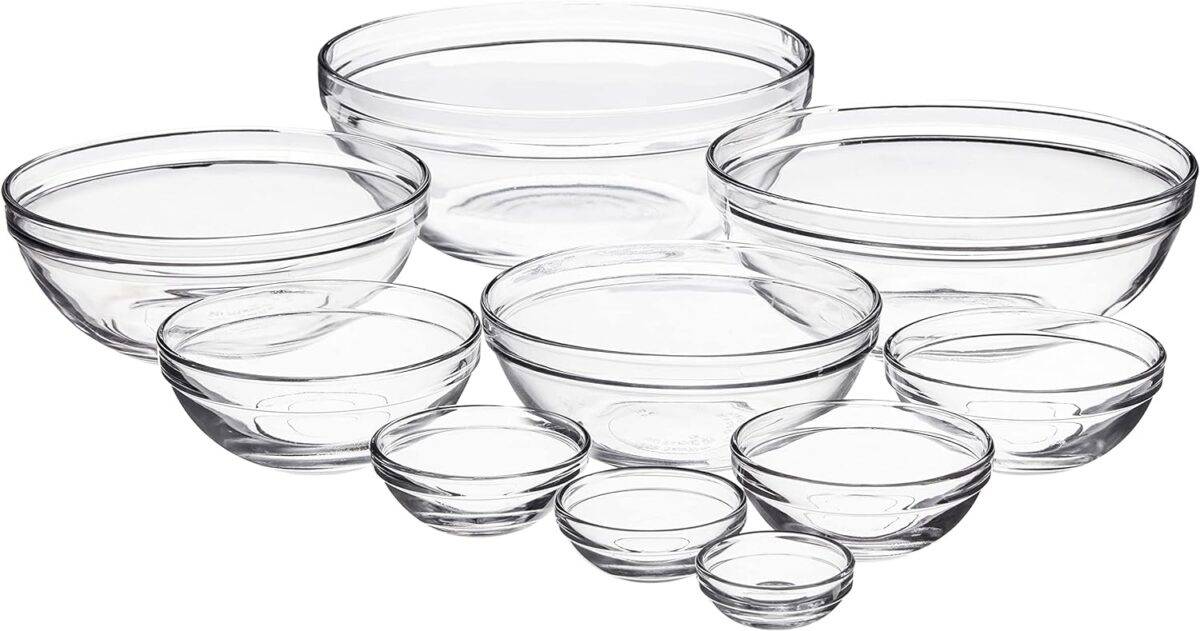 A set of clear glass mixing bowls in a variety of sizes is on a white background.