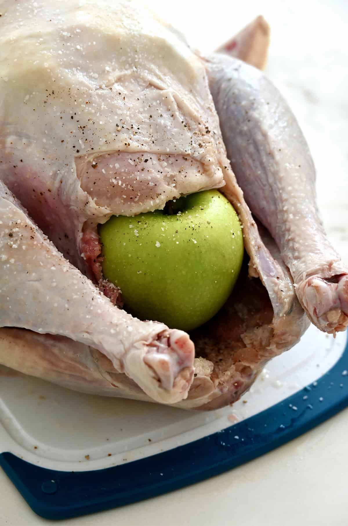 A whole Granny Smith apple propping open the cavity of a turkey so air can circulate inside while roasting.
