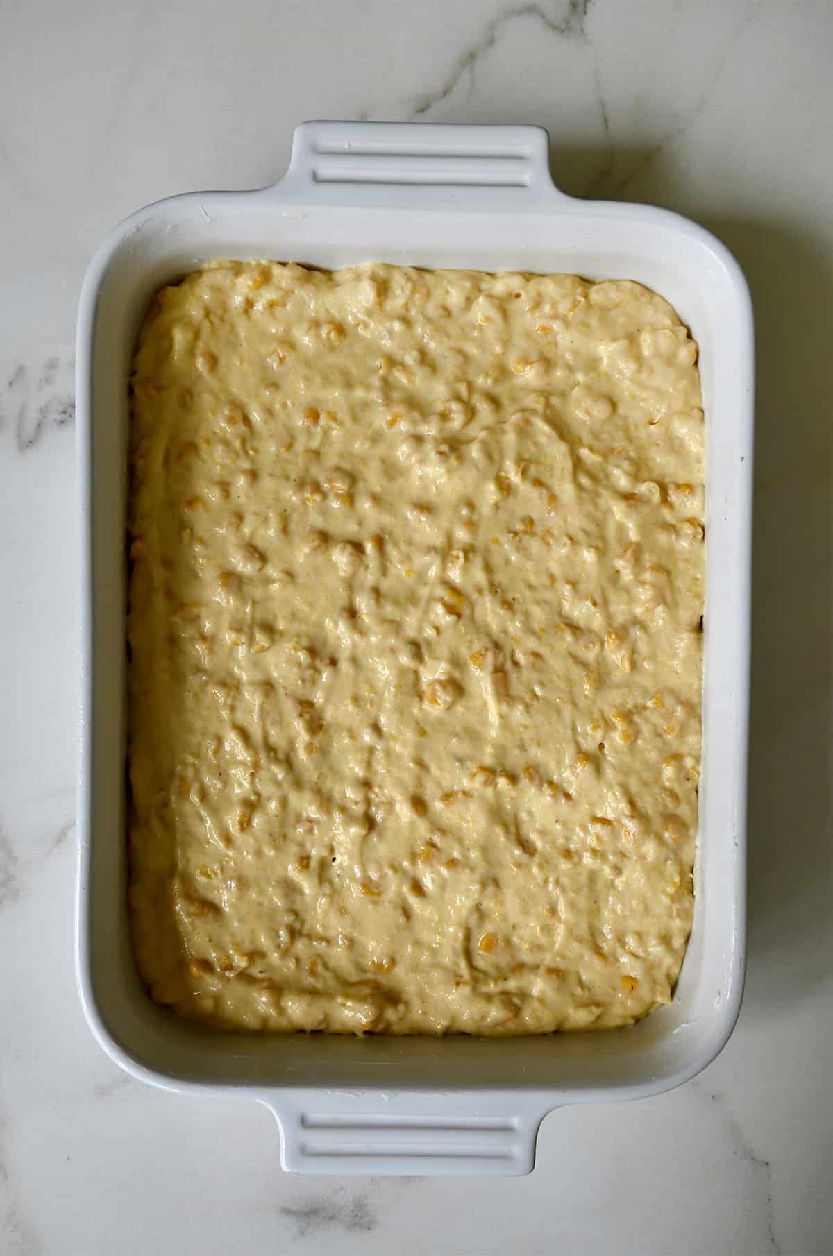 Corn pudding in a casserole dish before baking.
