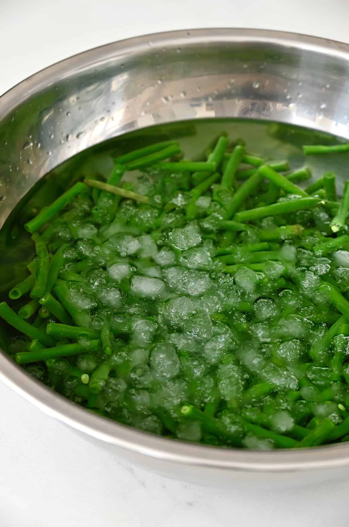 Blanched green beans in ice water.