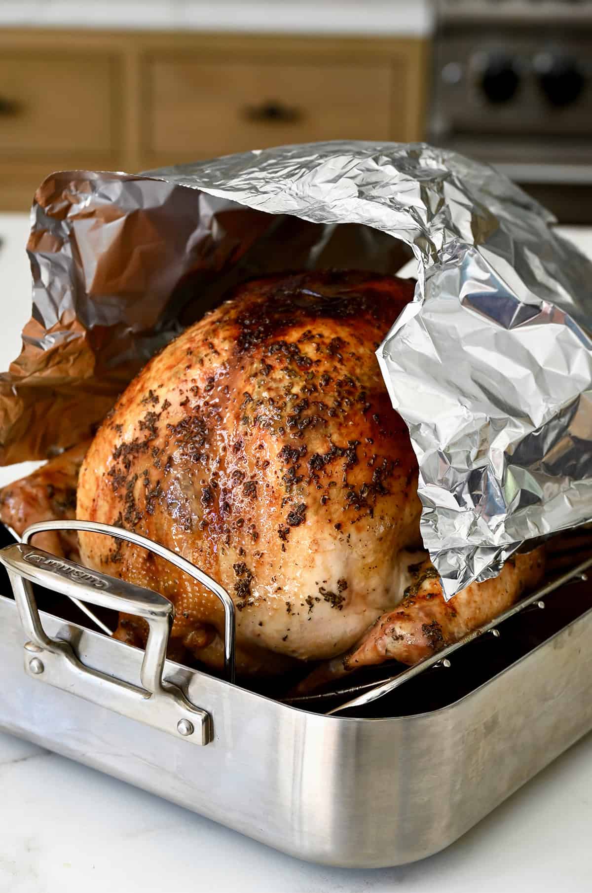 Tenting a roasted turkey with tinfoil to prevent over-cooking.