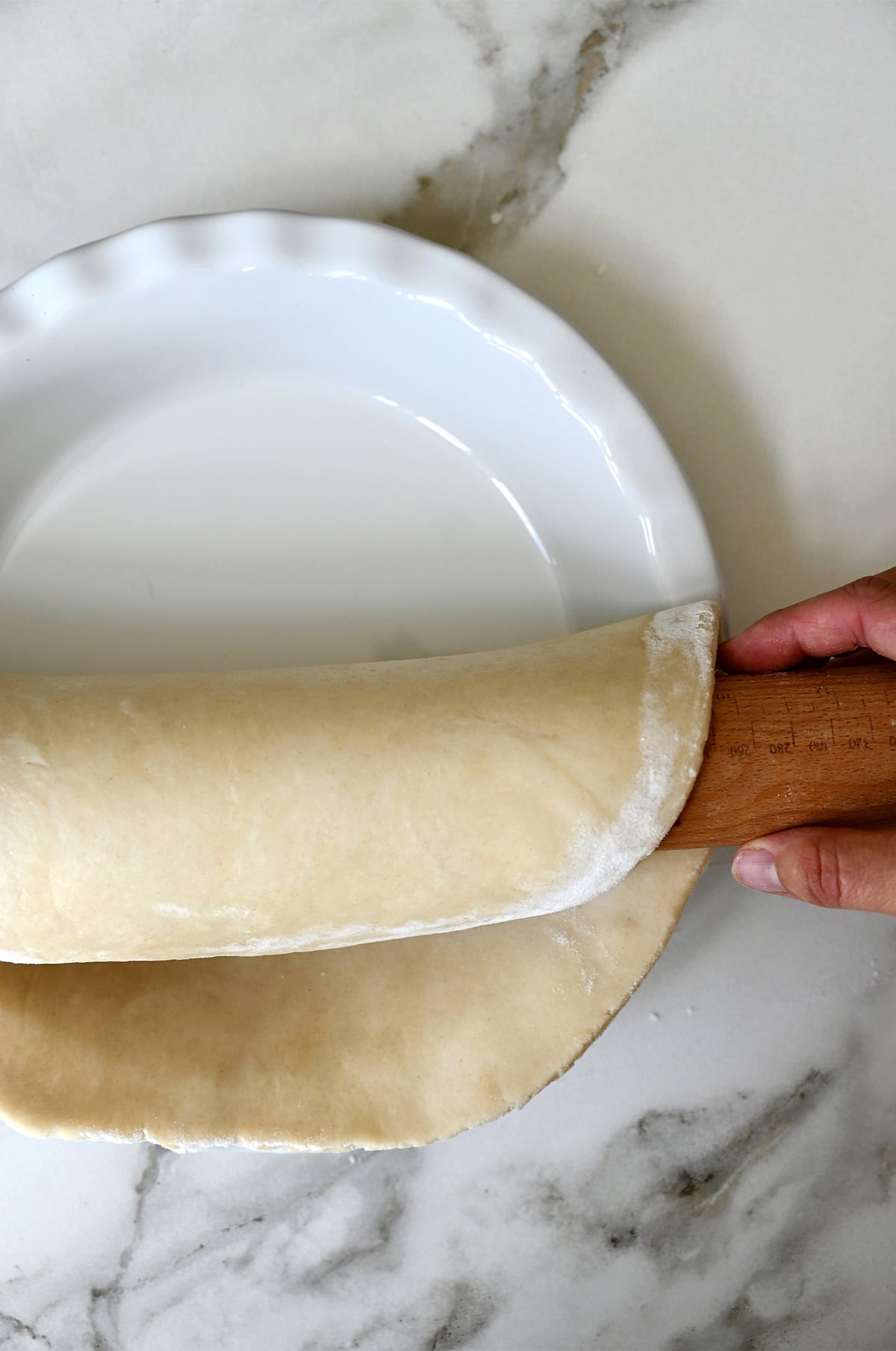Transferring pie dough into a pie plate.