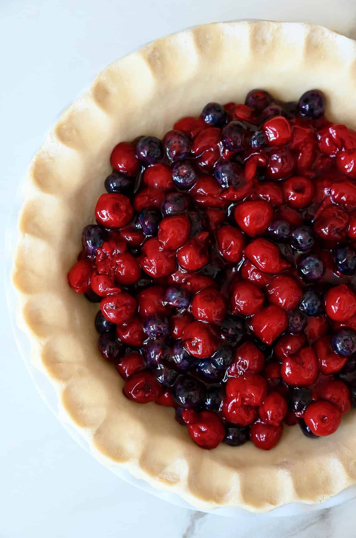 Unbaked pie crust with mixed berries.