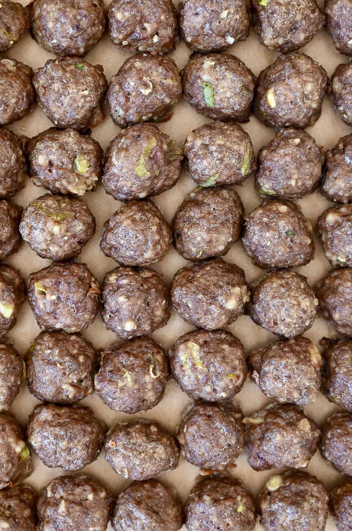 Baked cocktail meatballs lined up in perfect rows.