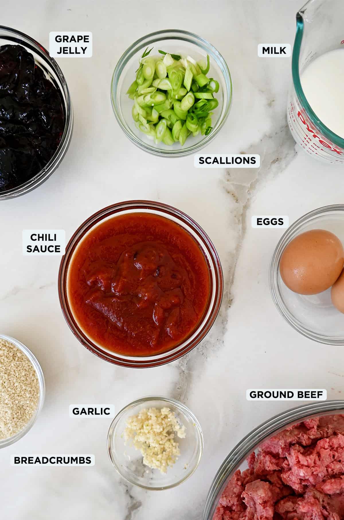Cocktail meatball ingredients in various sizes of glass bowls.