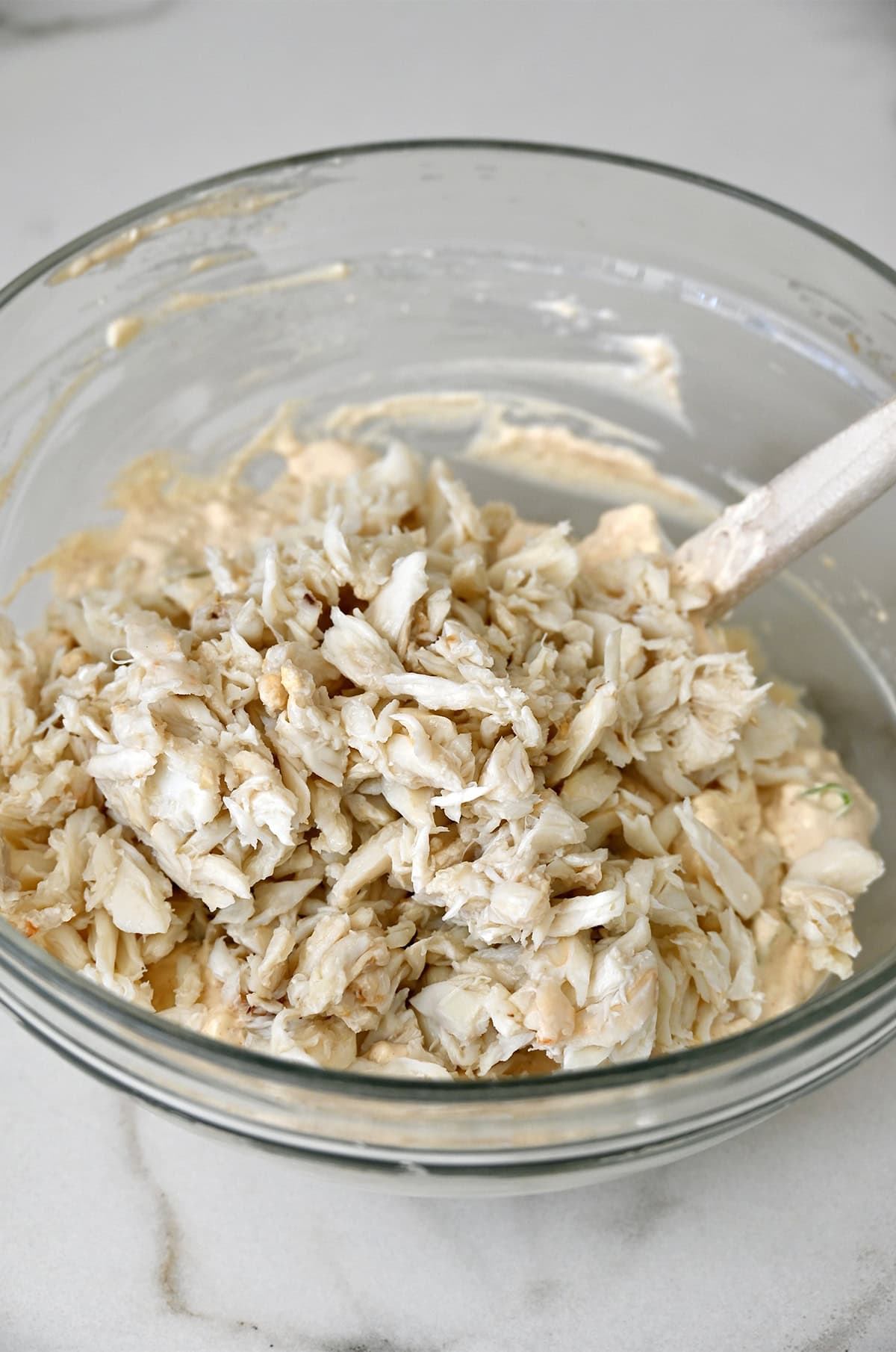 Lump crab dip mixture in a bowl with a spatula.
