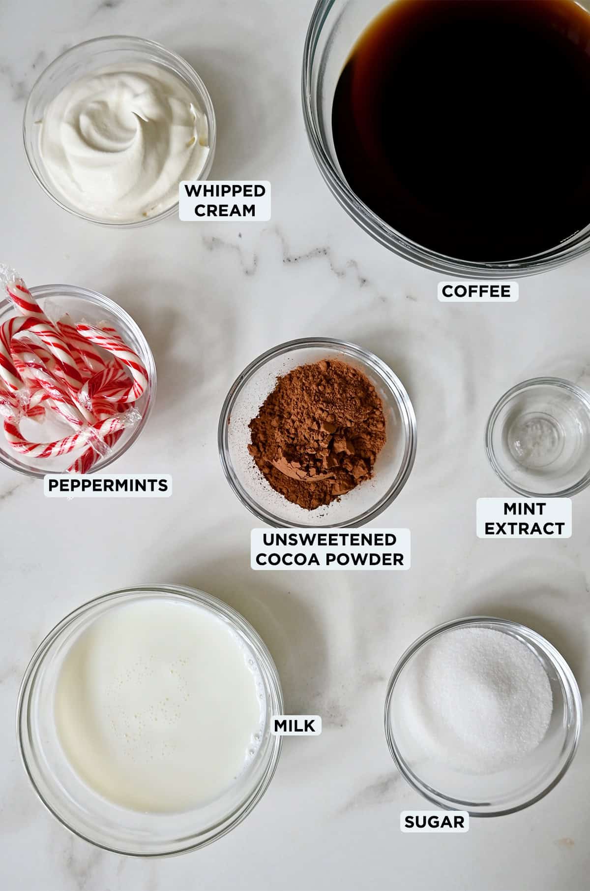 Various sizes of glass bowls containing ingredients to make a peppermint mocha.