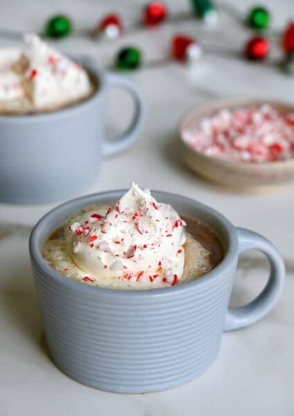 Two mugs filled with homemade peppermint mocha and topped with whipped cream.