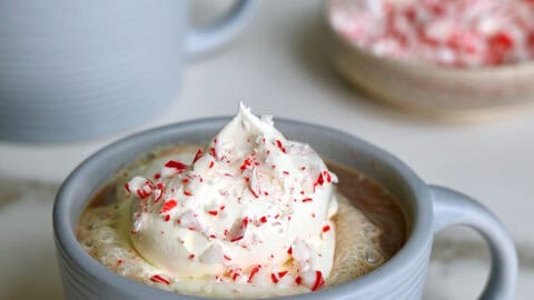 Two mugs filled with homemade peppermint mocha and topped with whipped cream.