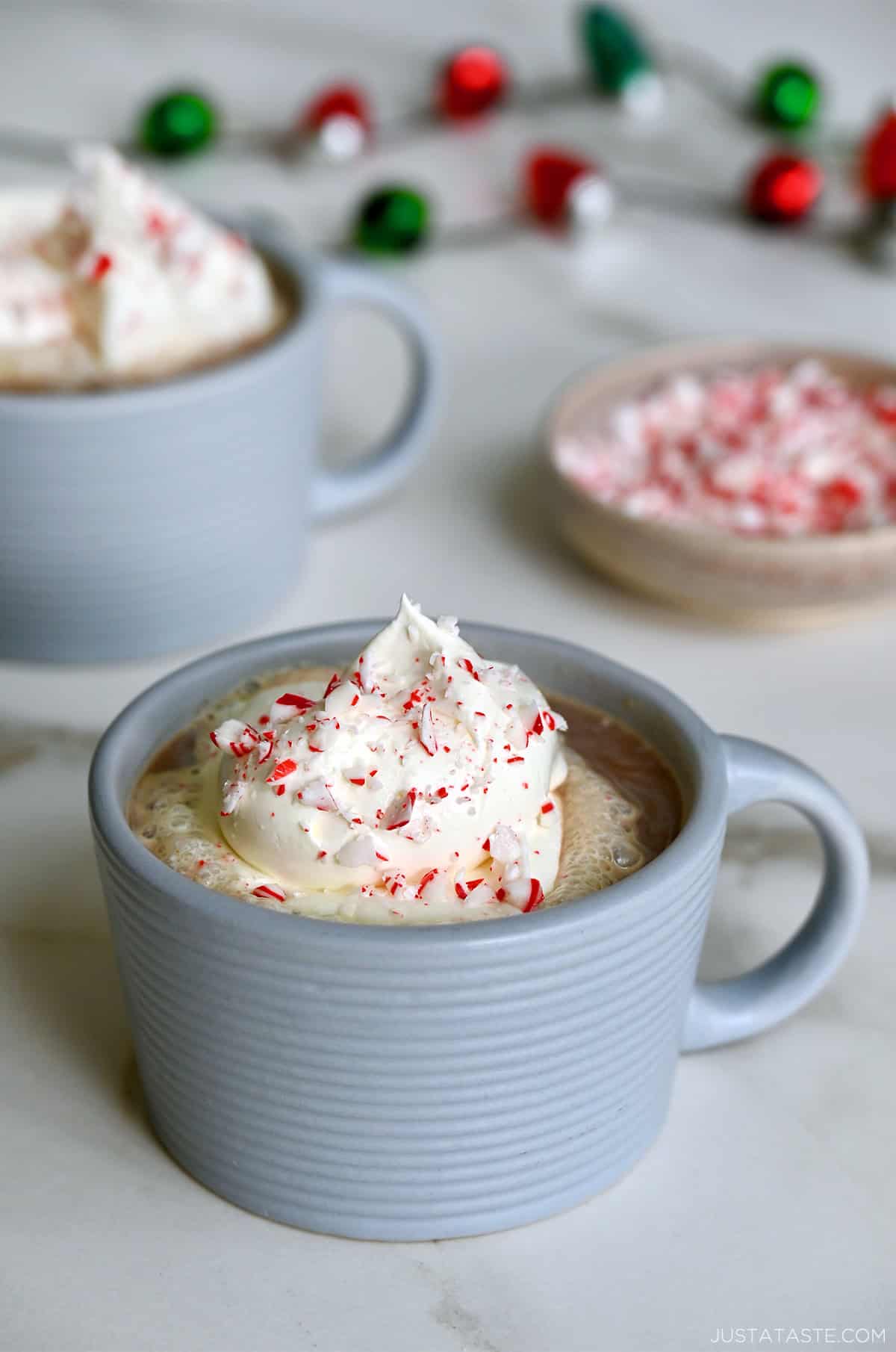 Two mugs filled with homemade peppermint mocha and topped with whipped cream.