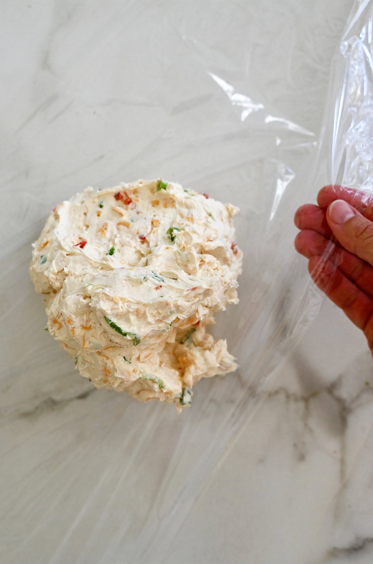 Shaping cheese mixture into a round ball.