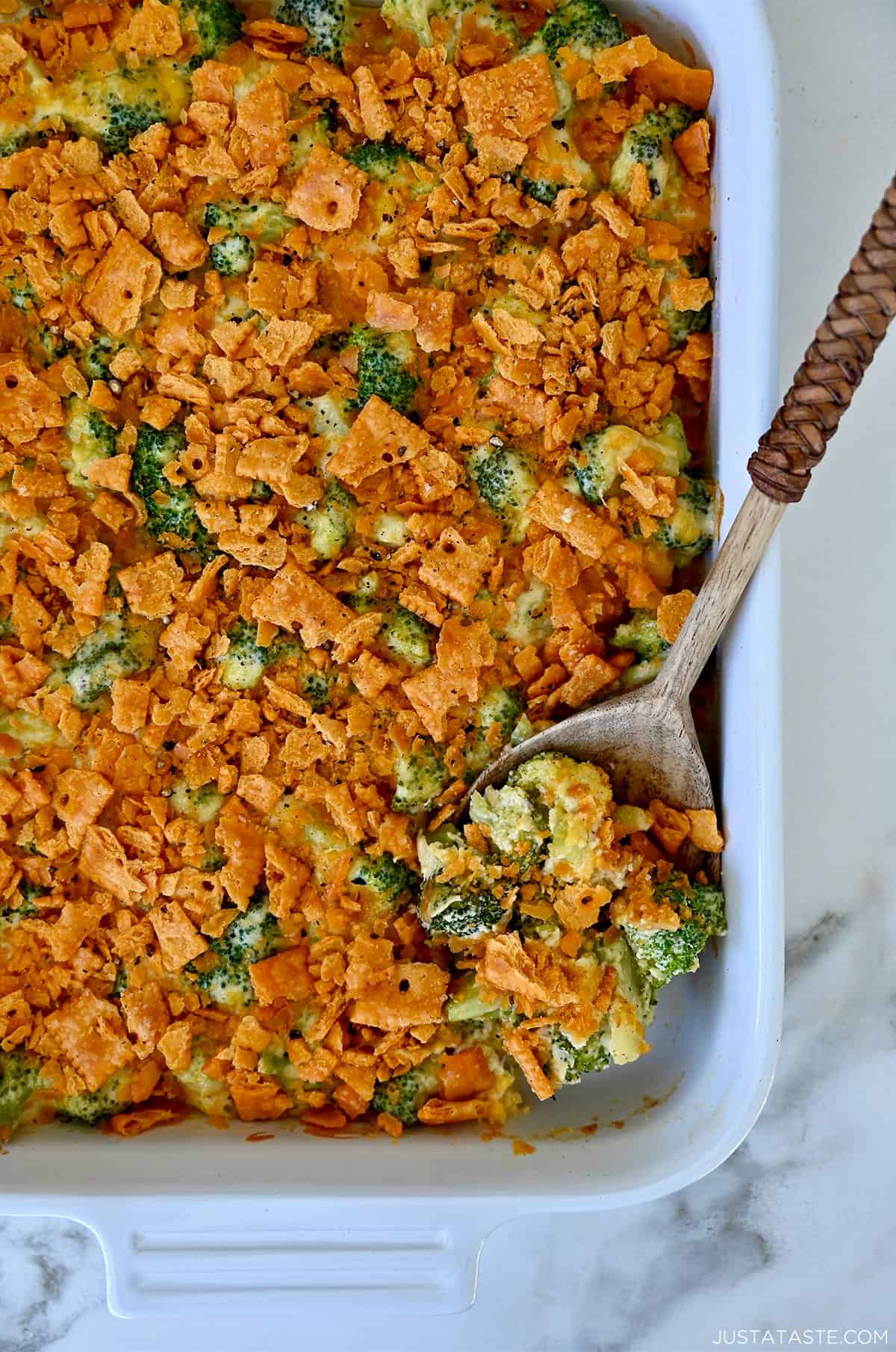 Broccoli cheese casserole topped with cheese crackers in a white casserole dish.